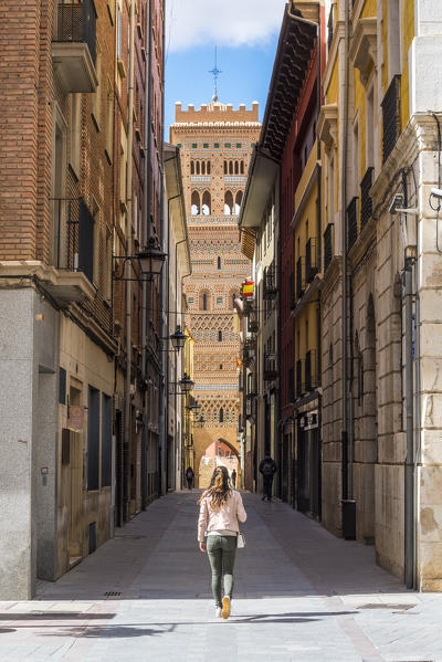 A tourist walks along the streets of Teruel. Saint Martin's tower in Background. Teruel, Aragon, Spain, Europe