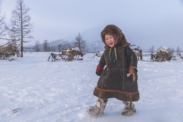 A young nenets boy dressed with the traditional coat. Daily life at the nomadic reindeer herders camp. Polar Urals, Yamalo-Nenets autonomous okrug, Siberia, Russia