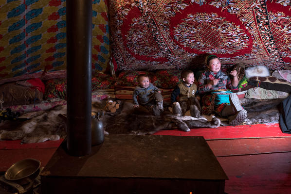 Nenets family in the tend. The traditional way of daily life at the nomadic reindeer herders camp. Polar Urals, Yamalo-Nenets autonomous okrug, Siberia, Russia