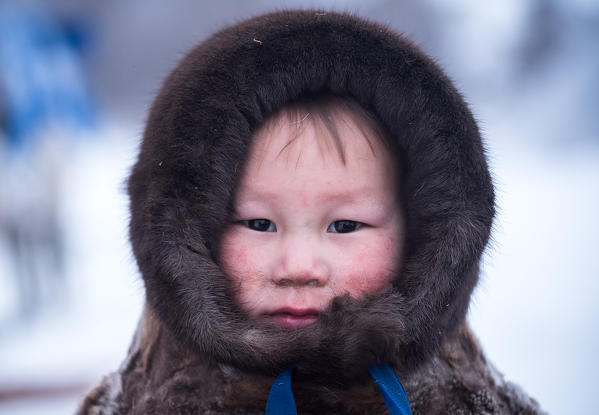 A small bay of nenets dressed with the traditional coat. Polar Urals, Yamalo-Nenets autonomous okrug, Siberia, Russia.