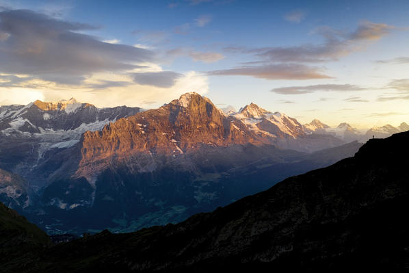 a climber enjoys a colorful sunset at Bachalpsee, Grindelwald, Oberland, Canton of Berne, Switzerland, Europe