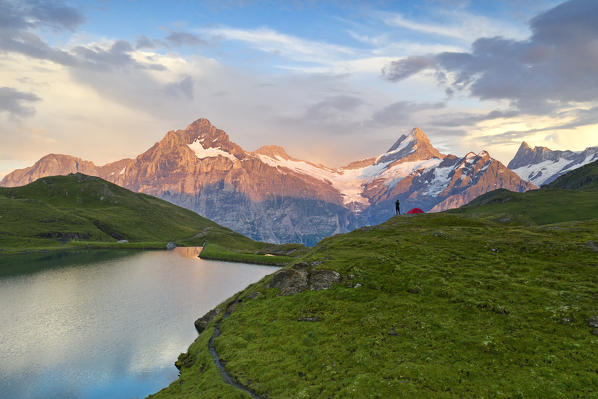 a climber enjoys a colorful sunset at Bachalpsee, Grindelwald, Oberland, Canton of Berne, Switzerland, Europe