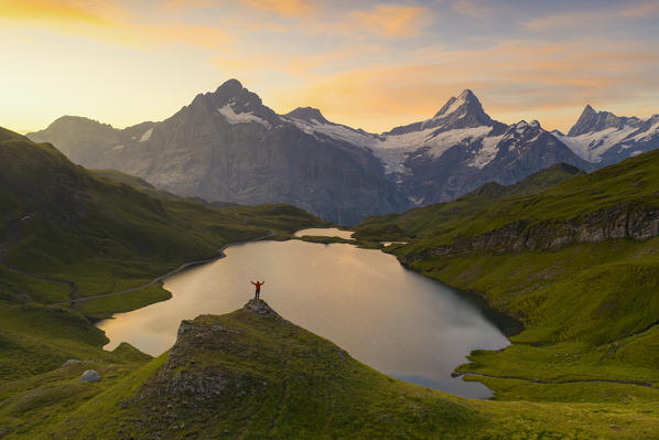 a climber enjoys a colorful sunset at Bachalpsee, Grindelwald, Oberland, Canton of Berne, Switzerland, Europe