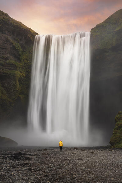 a traveller enjoy the sunset in front on the Skogafoss waterfall, Sudurland, Iceland, Europe