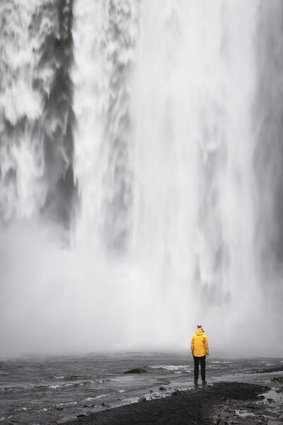 a traveller enjoy the Skogafoss waterfall, Sudurland, Iceland, Europe
