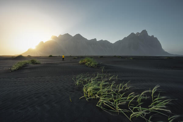 a traveller enjoy the sunset in front on the Vestrahorn mountain, Austurland, Iceland, Europe