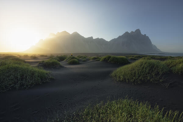 one person admire the Vestrahorn mountain during a summer sunset, Stokksnes, Hofn, Eastern Iceland, Iceland, Europe.