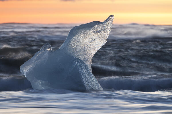a block of ice at Diamond Beach taken during a winter sunset, Jokusarlon Glacier Lagoon, Austurland, Iceland, Europe
