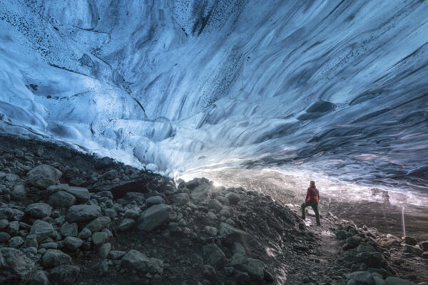 one hiker admiring one ice cave in Jokusarlon Glacier Lagoon area in winter time, Austurland, Iceland, Europe (MR)