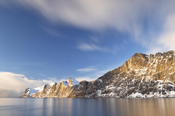 A long exposure to capture the coast near the iconic Segla mountain during a sunny winter day, Senja, Norway, Europe