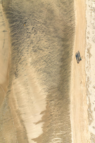 Aerial view taken from the drone of a beach on the island of Senja with the shadow of four people, Senja, Norway, Europe