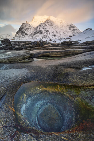 a long exposure to capture the sunset light at Uttakleiv beach during an winter day, with a famous eye of dragon in foreground, Vestvagoy, Lofoten island, Norway, Europe