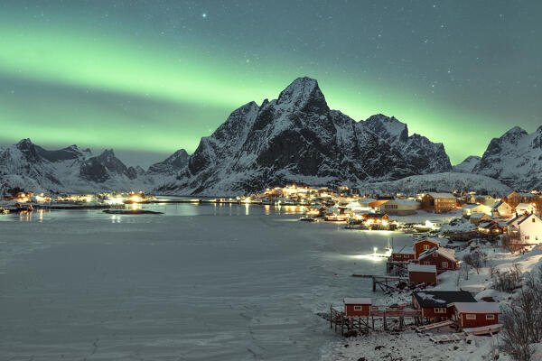 one person enjoy the magic of the arctic skies with the Northern Lights at Reine Lofoten island, Norway, Europe