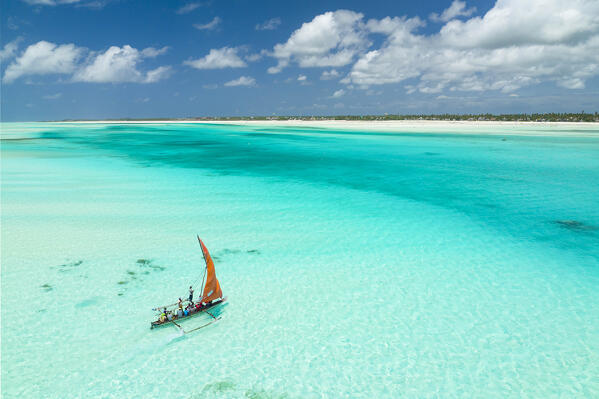 a Dhow plows through the sea of the lagoon during a magnificent sunny day, Zanzibar, Tanzania, Africa