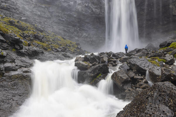 one person enjoy the beautiful waterfall callde Fossà during an autumn day, Streymoy, Faroe Islands, Denmark, Scandinavia, Europe