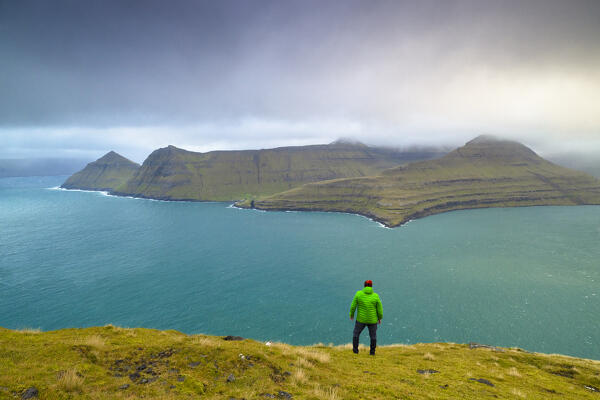 one person enjoy the beautiful view of Funningsførdur from Gonguturur Hvithamar trailhead, Sunda municipality, Eysturoy, Faroe Islands, Denmark, Scandinavia, Europe