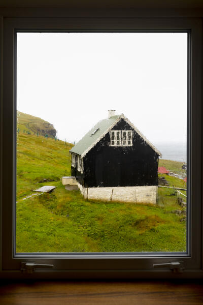 the houses of the village of Gjogv seen through a window, during an autumn day, Eysturoy, Faroe Island, Denmark, Europe