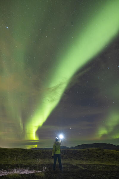 one guy admire the majestic Northern Lights during an autumn night, near to Gullfoss waterfall, Iceland, Europe