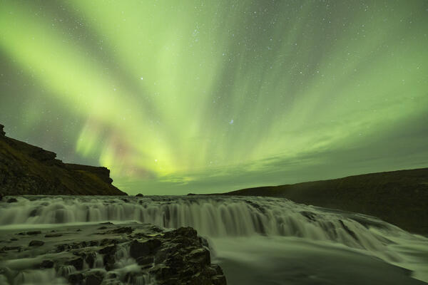the Northern Lights over iconic Gullfoss waterfall during an autumn night, Iceland, Europe