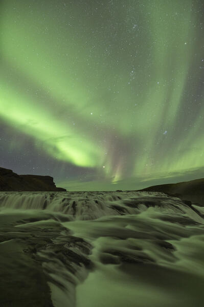 the Northern Lights over iconic Gullfoss waterfall during an autumn night, Iceland, Europe