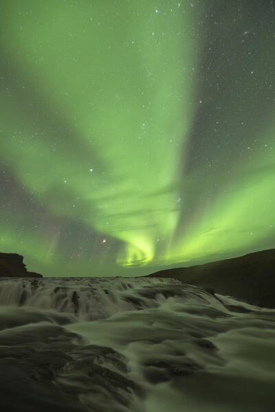 the Northern Lights over iconic Gullfoss waterfall during an autumn night, Iceland, Europe