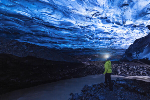 a girl explore the Ice Cave on Vatnajokull glacier near to Jokusarloon glacier lagoon, Iceland, Europe (MR)