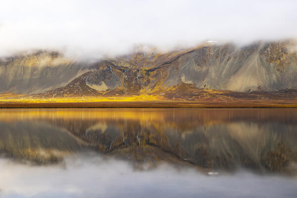 the mountain is mirrored in the glacial lake during the autumn time, Iceland, Europe