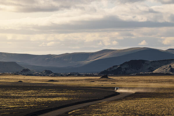a car driving along the gravel road in Landmannalaugar park during a summer day, Iceland, Europe