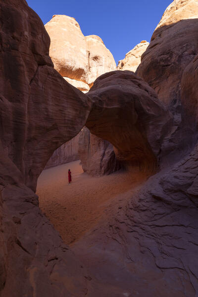 a girl admiring the beautiful rock formation in Arches National Park during a summer sunny day, Utah, United States of America
