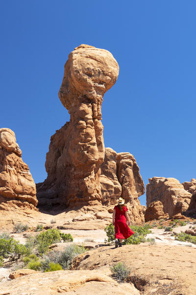 a girl admiring the beautiful rock formation in Arches National Park during a summer sunny day, Utah, United States of America (MR)