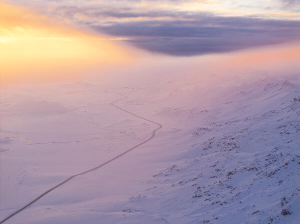 an aerial view taken by drone of the road that runs along Lake Kleifarvatn, during a magnificent winter sunset, Iceland, Europe