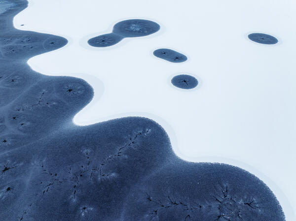vertical aerial view from a drone of particular ice formations formed in the fjord during a cold winter day, Grundafjordur, Iceland, Europe