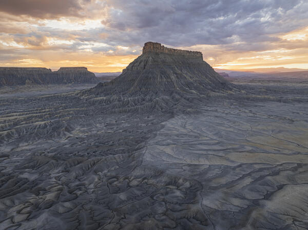 a warm light of the sunset envelope the majestic rock formation in of Factory Butte near to Capitol Reef National Park during a summer day, Utah, United States of America