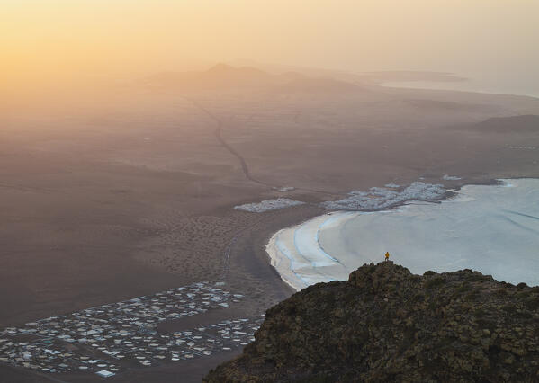 Aerial view of a man observes Famara beach from Risco de Famara at sunset, Famara, Las Palmas, Lanzarote, Canary Islands, Macaronesia, Spain, Western Europe