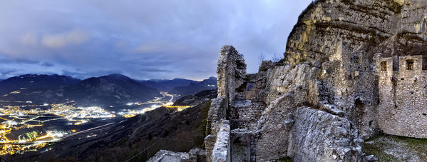 The citylights of Rovereto seen from the medieval ruins of Corno Castle. Isera, Trento province, Trentino Alto-Adige, Italy, Europe.