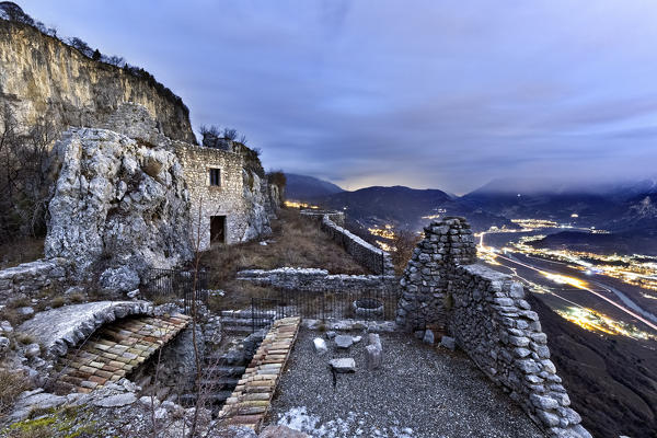 Medieval ruins of Corno Castle and the citylights of Rovereto. Isera, Trento province, Trentino Alto-Adige, Italy, Europe.