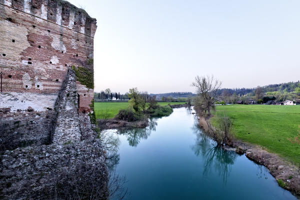 The ancient walls of the Visconteo bridge and the river Mincio. Verona province, Veneto, Italy, Europe.