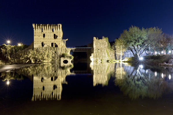 The ancient walls of the Visconteo bridge are reflected in the Mincio river. Verona province, Veneto, Italy, Europe.