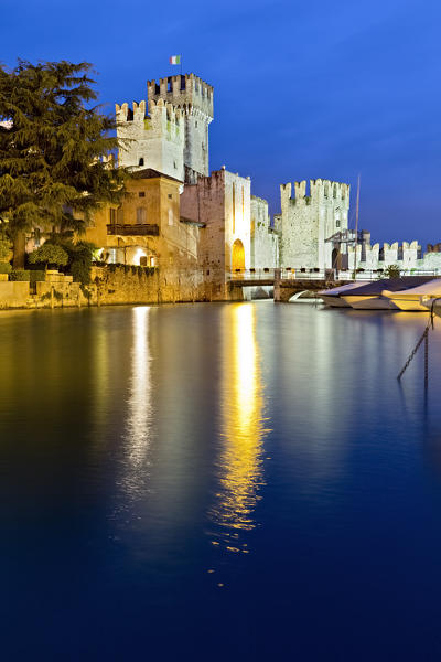 The Scaligero castle in Sirmione is reflected in Lake Garda. Brescia province, Lombardy, Italy, Europe.