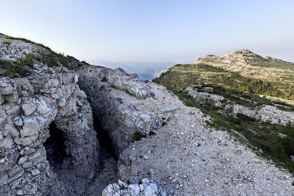 Monte Ortigara: Austro-Hungarian trenches and shelters of the Great War carved into the rock. In the background Cima della Caldiera. Asiago plateau, Vicenza province, Veneto, Italy, Europe.