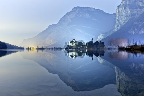 Toblino castle, manor of ancient legends, is reflected in the lake waters. Madruzzo, Trento province, Trentino Alto-Adige, Italy, Europe.
