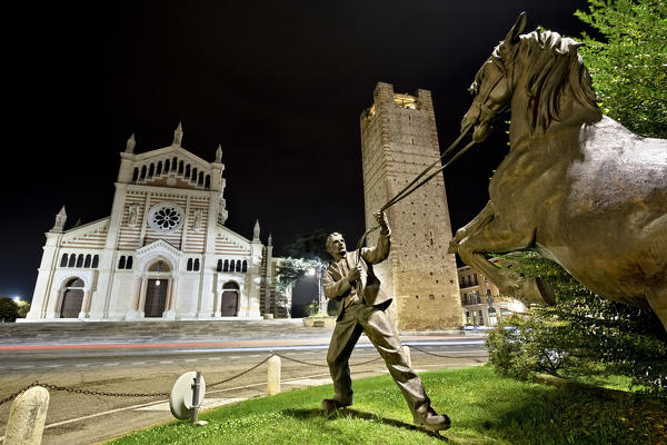 The sculpture of the Lonigo horse fair. In the background the cathedral and the Scaliger tower. Vicenza province, Veneto, Italy, Europe.