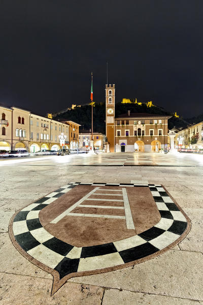 Marostica Chess Square: the coat of arms of the Scaliger dynasty and the Doglione palace. In the background the medieval castle. Vicenza province, Veneto, Italy, Europe. 