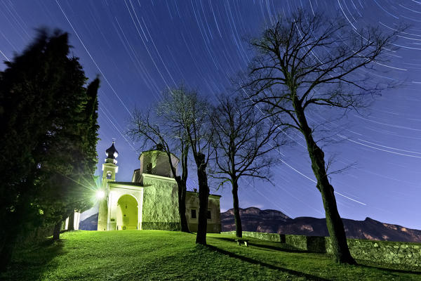 Star trails above the San Valentino sanctuary. Trento province, Trentino Alto-Adige, Italy, Europe