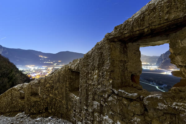 Moonlight on the medieval wall of San Gottardo Castle. In the background the Rotaliana plain. Trento province, Trentino Alto-Adige, Italy, Europe.