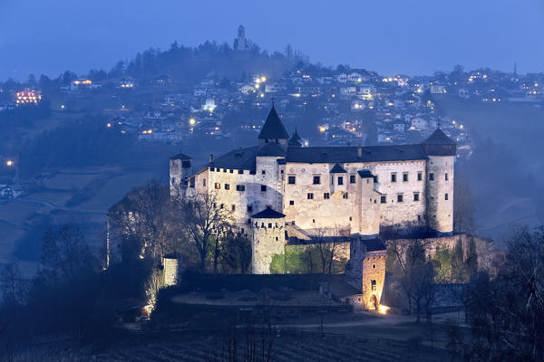 The Presule Castle is a medieval fortification in the Gothic style. In the background the village of Fiè allo Sciliar. Bolzano province, Trentino Alto-Adige, Italy, Europe. 