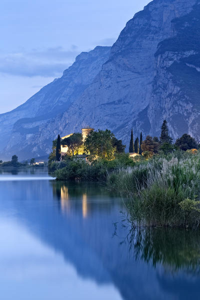 Night falls on Lake Toblino and its castle. In the background mount Casale. Madruzzo, Trento province, Trentino Alto-Adige, Italy, Europe.