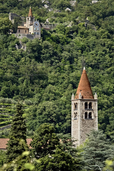 The bell tower of the  Santo Stefano church in Mori. In the background the sanctuary of Santa Maria di Montalbano. Trento province, Trentino Alto-Adige, Italy, Europe.