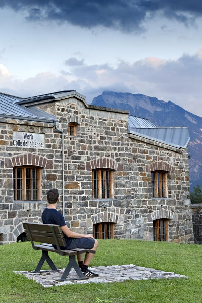 Man sitting on a bench at fort Colle delle Benne. Levico Terme, Trento province, Trentino Alto-Adige, Italy, Europe.