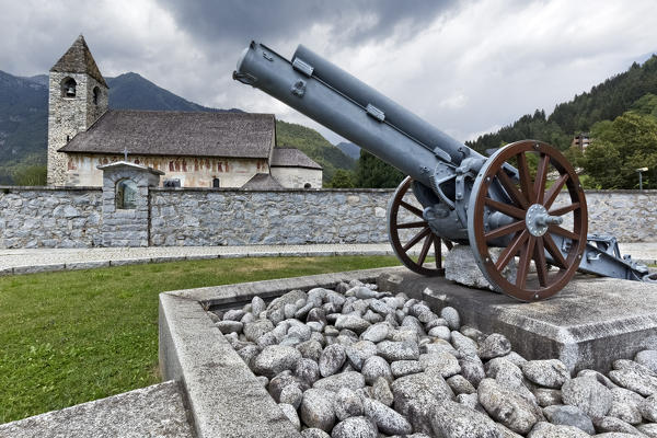 The Skoda cannon of the Great War and the San Vigilio church in Pinzolo. Rendena Valley, Trento province, Trentino Alto-Adige, Italy, Europe.